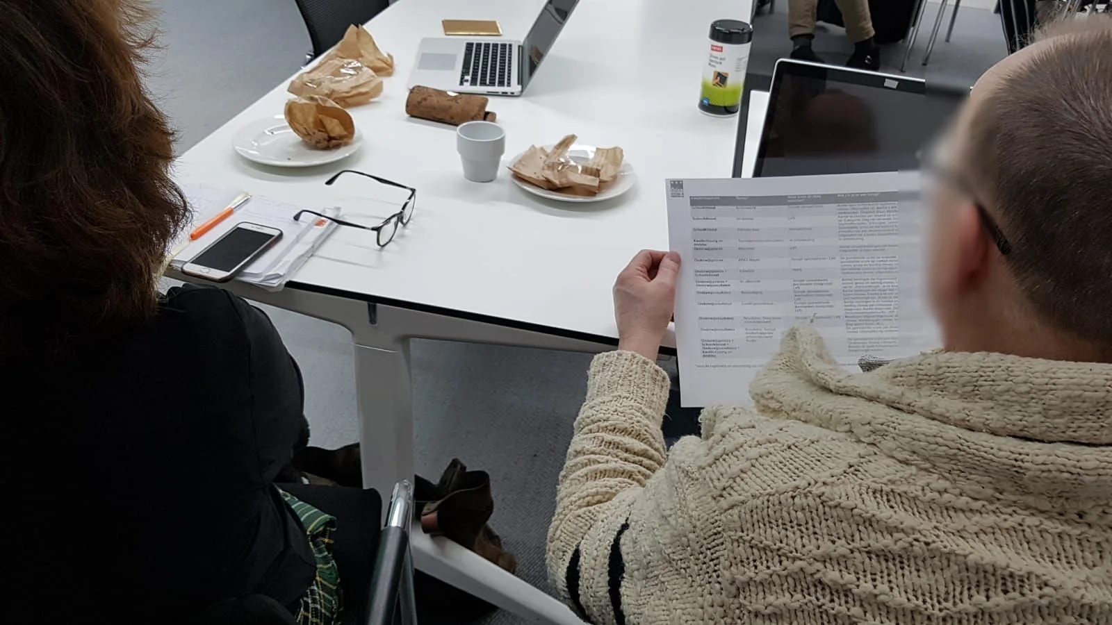 Deelnemer leest een hand-out van Stichting Orion met een tabel van datasets